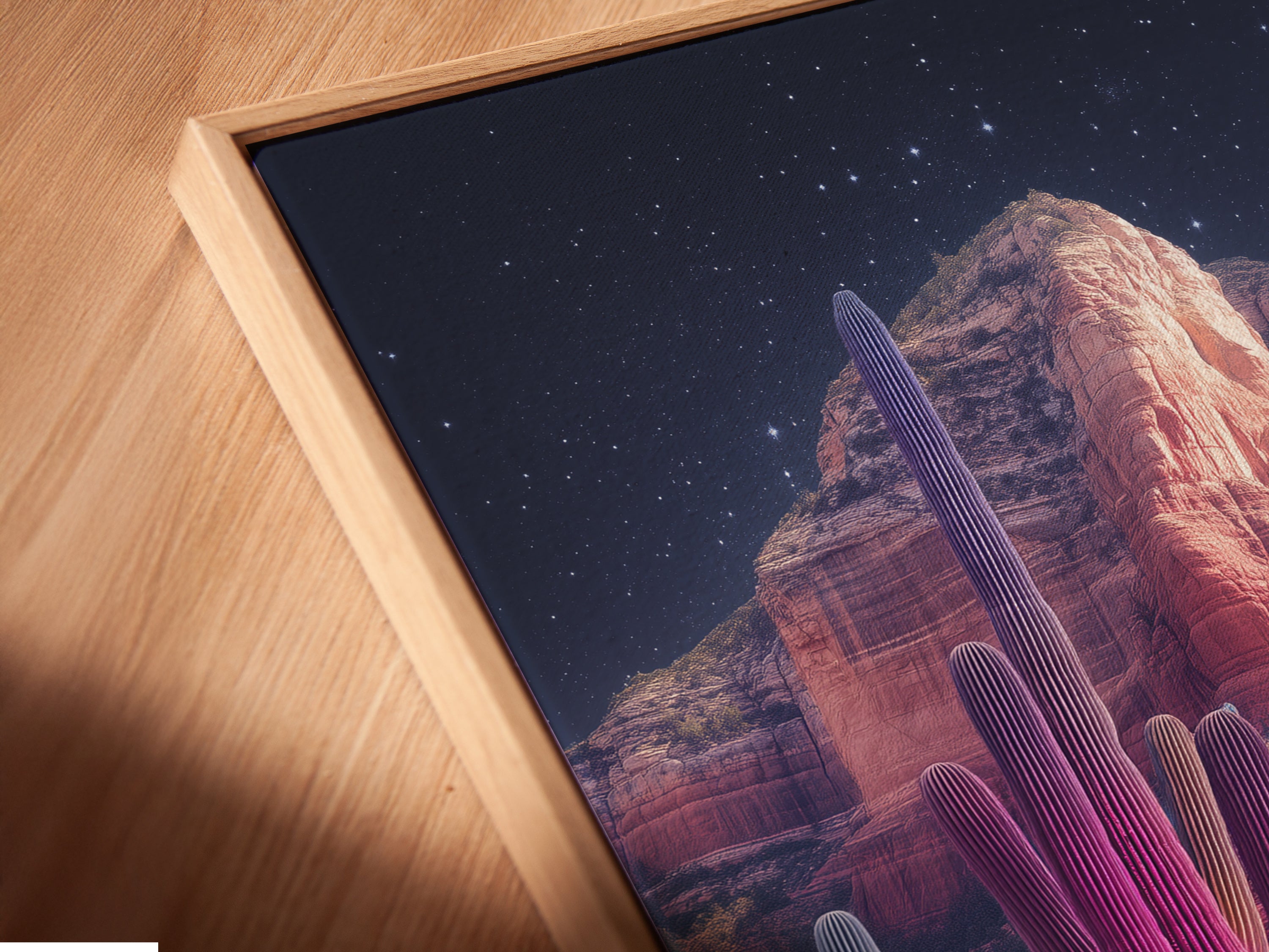 A close-up angled view of a canvas print in a floating frame. The artwork features a neon cactus and desert landscape. The floating frame enhances the modern look of this southwestern wall art. Perfect for home wall decor and creating desert vibes.
