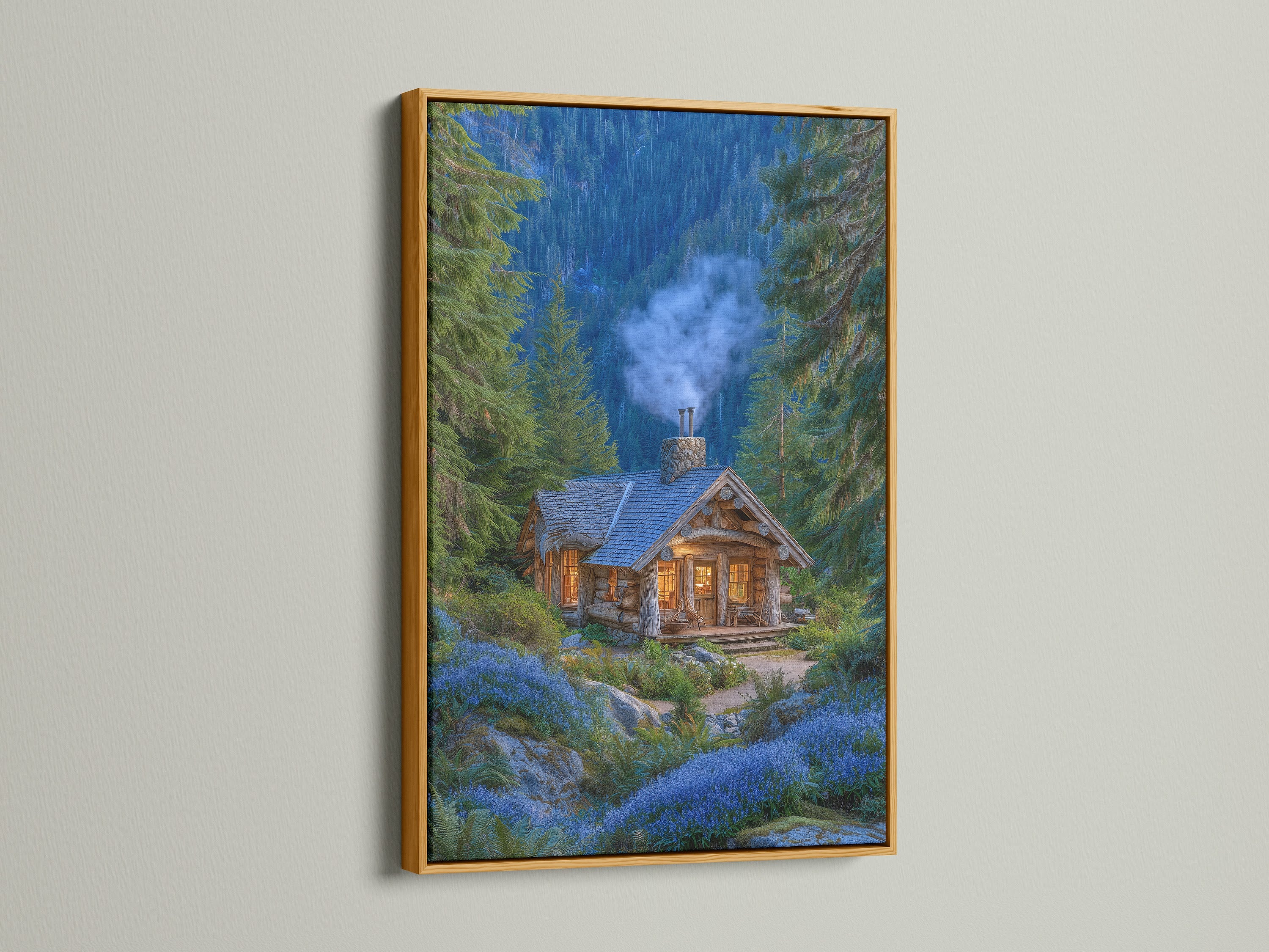 A framed forest cabin artwork with a gold frame is displayed. The artwork features a cozy mountain lodge nestled among pine trees and blue flowers. This rustic woodland cottage art brings nature indoors. The gold frame adds a touch of elegance and warmth.