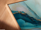 A close-up shot reveals a canvas print in a floating frame. The abstract blue and gold artwork appears to float. This contemporary art piece adds depth and dimension. Ideal for modern wall decor in offices or bedrooms. The floating frame enhances its artistic appeal.