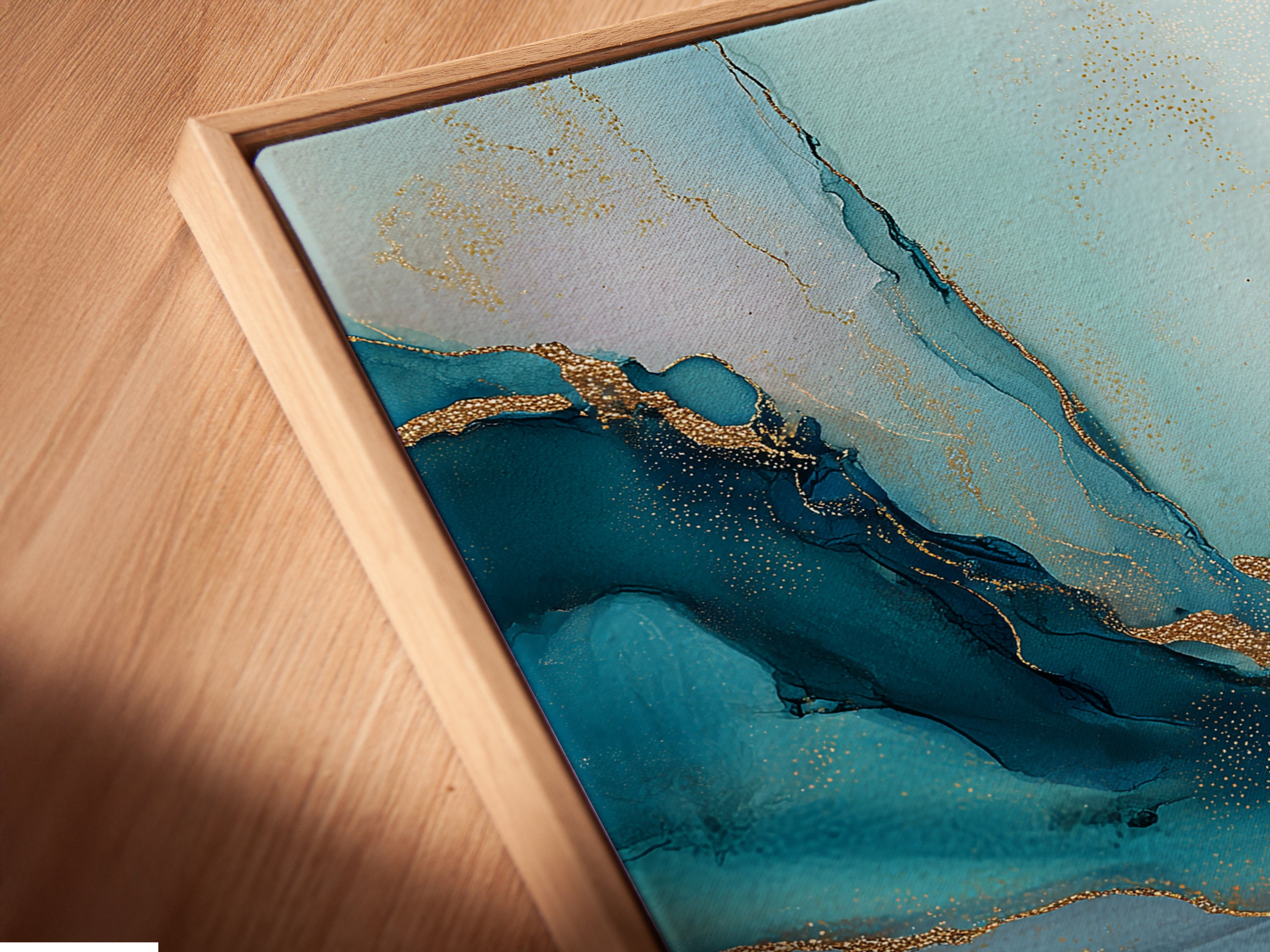 A close-up shot reveals a canvas print in a floating frame. The abstract blue and gold artwork appears to float. This contemporary art piece adds depth and dimension. Ideal for modern wall decor in offices or bedrooms. The floating frame enhances its artistic appeal.
