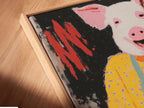Angled close-up of a Pig Baker canvas print. The artwork is displayed in a floating frame. This whimsical piece enhances any space. The canvas adds a touch of elegance. See the texture and detail.