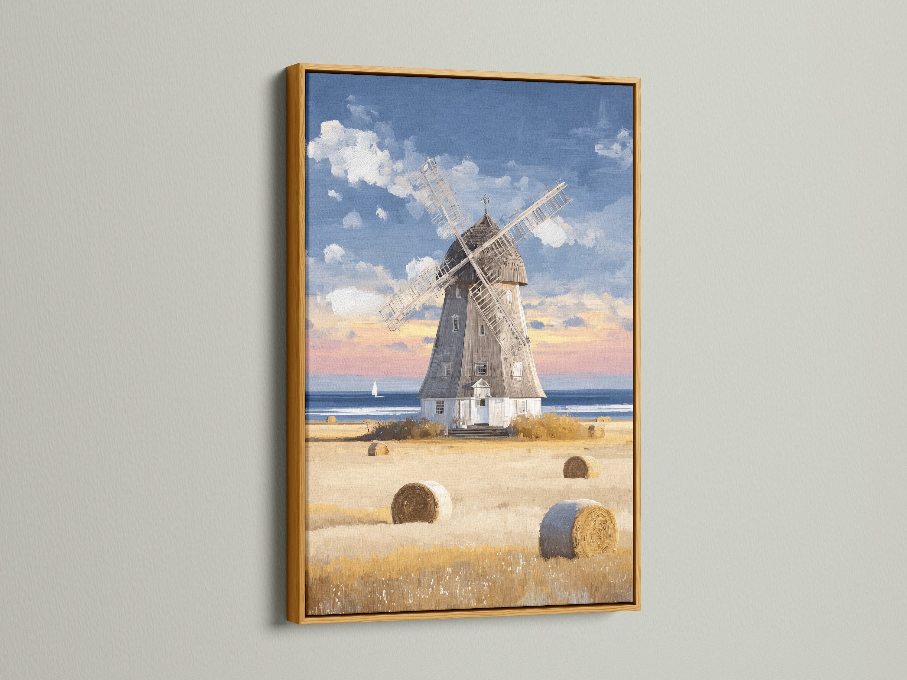 A gold frame highlights this coastal countryside artwork of a vintage windmill. Golden hay bales add warmth to the scene. Perfect for adding a touch of elegance to your decor this framed art complements various interior styles. This artwork brings vintage farmhouse charm and seaside tranquility to any room.