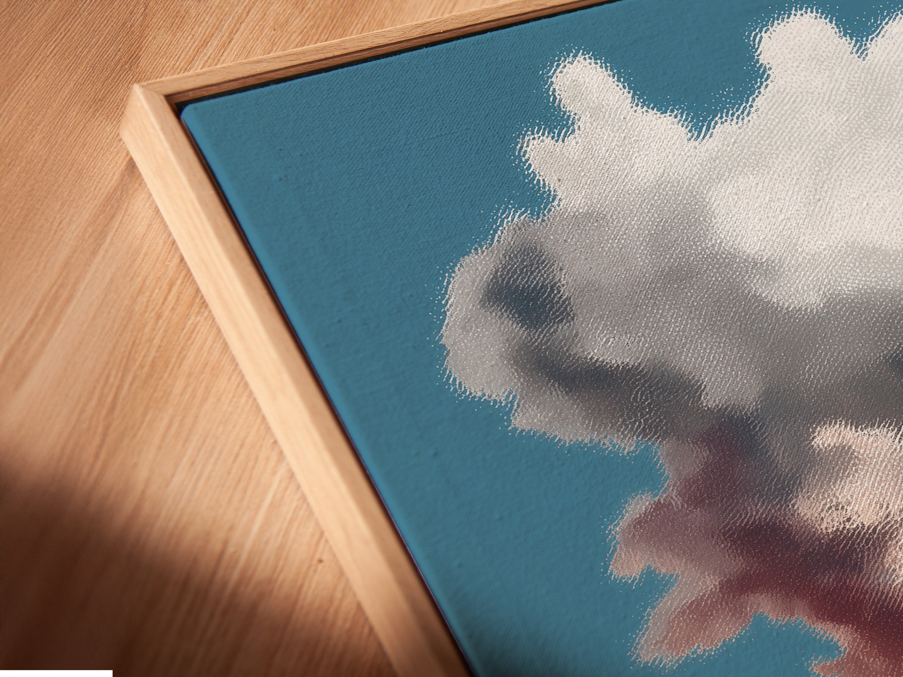 Close-up of a Canvas Print in a Floating Frame. This surreal coffee cup artwork displays a desert landscape. The dreamy cloudscape enhances any space. The floating frame adds a modern touch. Perfect for contemporary art enthusiasts.