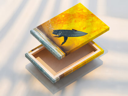 A stretched canvas print featuring surfing artwork. The artwork captures a surfer riding a wave against a yellow sunset. This stretched canvas is perfect for adding a coastal touch to any space. Ideal for living rooms beach houses and surf shops.