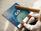 A woman carefully rolling a fine art poster paper print of the blue bird artwork. The poster captures the intricate details and vibrant colors. Perfect for creating a charming and comforting atmosphere in any room. The high-quality paper ensures a lasting and beautiful display of this delightful piece.