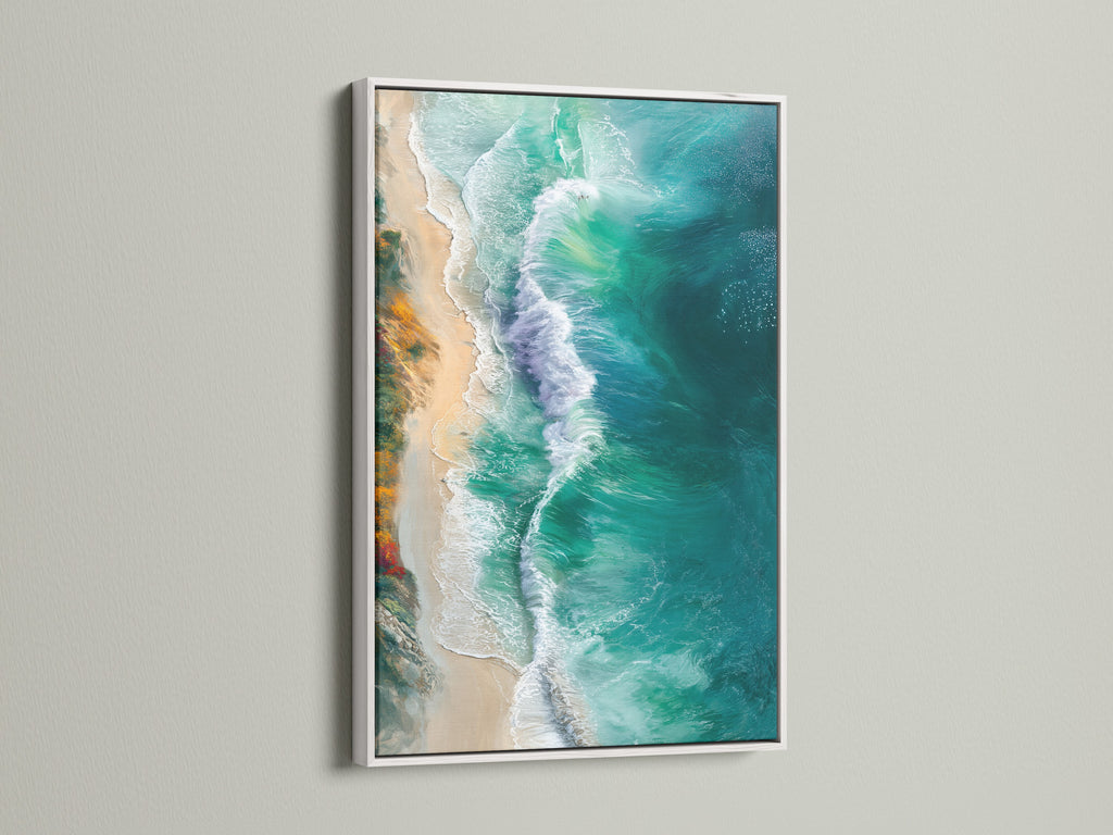 A white frame surrounds an ocean artwork print. The artwork captures turquoise waters and beach waves. This coastal wall art adds a fresh serene touch. It's ideal for minimalist or modern aesthetics.