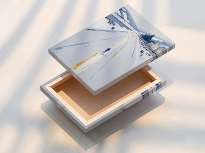 This image showcases a stretched canvas print of the Winter Cityscape artwork. The snowy street print is ready to hang and enjoy. Perfect for minimalist Scandinavian coastal rustic or industrial styles. Add a touch of winter to your living room bedroom or office.