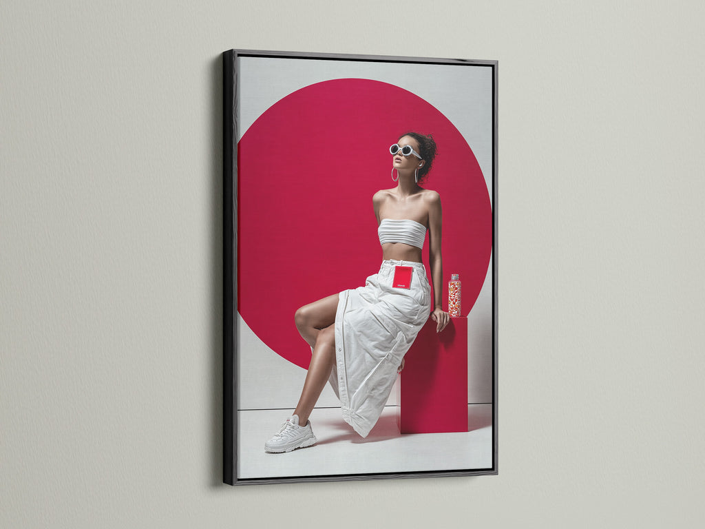 Modern fashion artwork displayed in a sleek black frame. The pop art canvas features a woman in a white ensemble with a striking red background. The black frame adds a touch of sophistication. A great piece for contemporary art lovers.