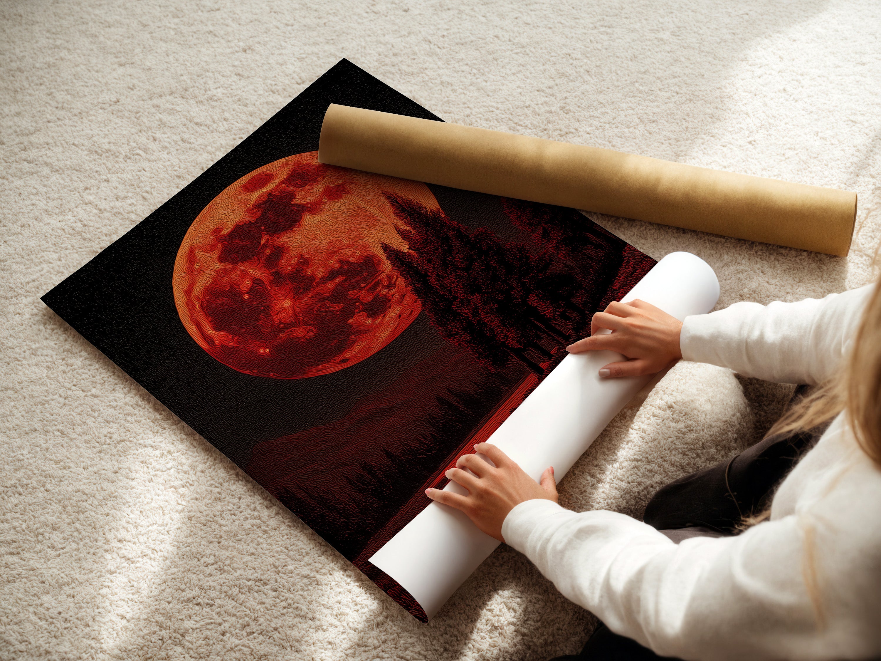 A woman is carefully rolling a fine art poster paper. The paper features a captivating red moon and forest landscape. Perfect for creating high-quality celestial art prints. Order yours today and make some art.