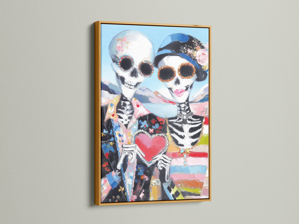 Sugar skull art displayed in a gold frame. This Dia de los Muertos canvas print features a couple skeleton. The colorful art and gothic decor make it a standout piece. It enhances any home altar art display.