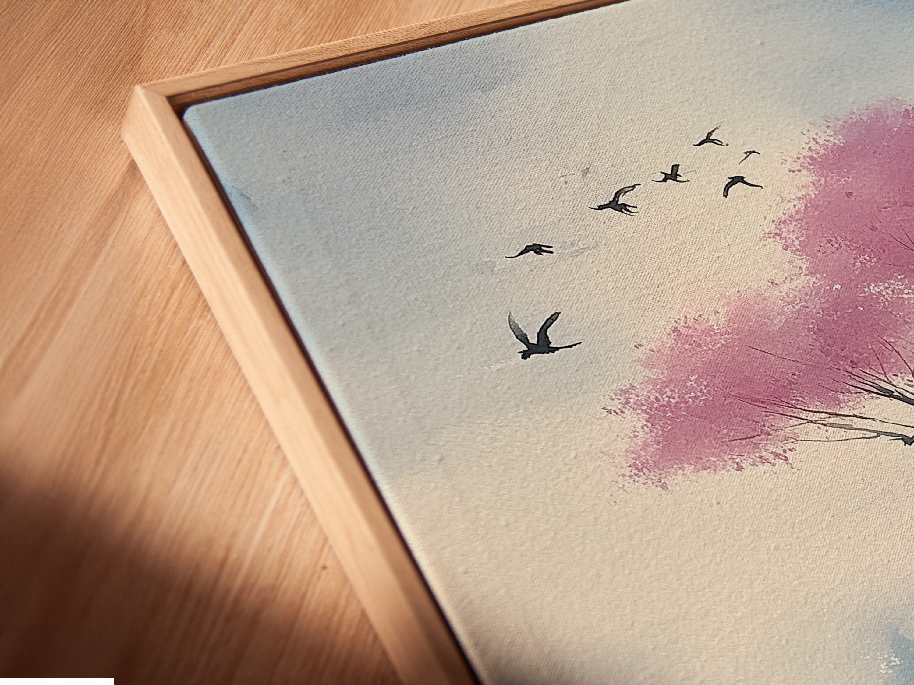 Angled close up of a canvas print in a floating frame. The Japanese Cherry Blossom artwork features an Asian landscape. This watercolor painting is great for office decor. It is a blossom canvas. It is a sakura art perfect for any space. 