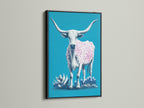 A longhorn cow artwork showcased in a black frame. The artwork features a turquoise background. A cow with pink spots stands out. The black frame adds a bold contrast. This piece is perfect for a sophisticated western theme.