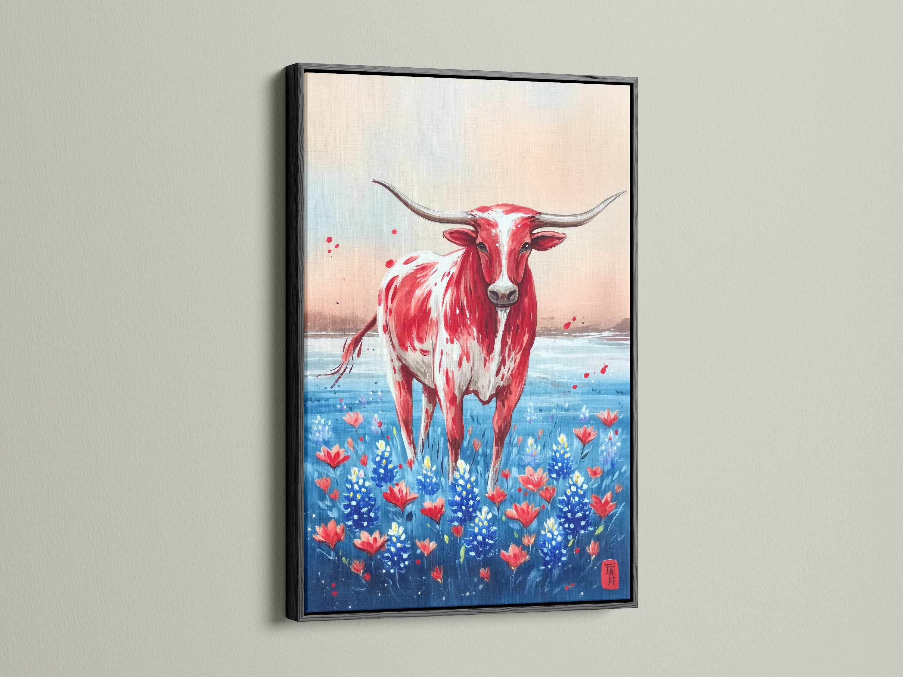 Texas Longhorn art in a black frame. The artwork features a striking red and white Longhorn in a field of wildflowers. Enhance your home decor with this western canvas art. Ideal for farmhouse or ranch-style interiors.