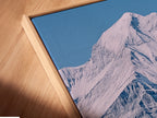 This is a close-up of a canvas print in a floating frame. The angled view highlights the details. This rustic wall decor adds depth to any room. The floating frame gives a modern touch. The snowy ridge landscape is beautifully showcased. This artwork enhances farmhouse western or ranch styles.