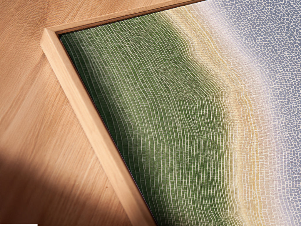 Angled close up of a canvas print in a floating frame. The abstract river artwork creates a modern organic flow. The floating frame enhances the artwork's depth. It is perfect for adding a contemporary print to any room.