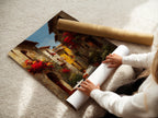 Woman rolling a fine art poster paper. The poster features a vibrant Italian street scene with red flowers. The fine art paper enhances the art's colors and details. The woman carefully handles the poster. This showcases the care in packaging the artwork.