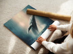 A woman is rolling a fine art poster paper. It is ocean wildlife wall art. It features a humpback whale. This is marine life artwork. The whale artwork is perfect for coastal wall decor. It is a sea life print.