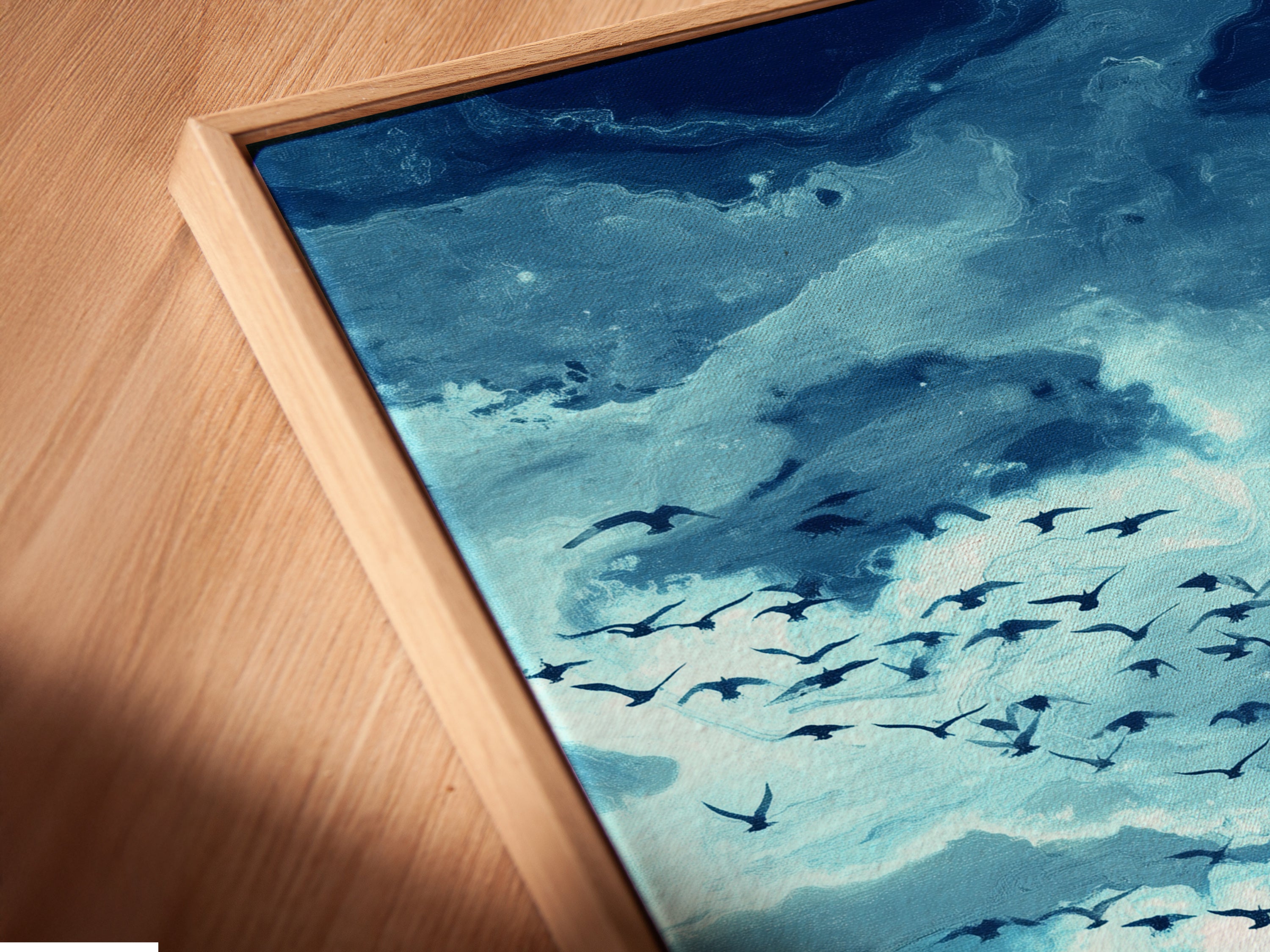 Close-up of a canvas print in a floating frame. The seascape artwork features a teal sky and birds. Perfect for adding a modern touch to any room. See the fine details and quality of this stunning coastal wall art a beautiful sky reflection