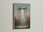 A framed UFO Cat art print with an oak frame. This whimsical alien wall art adds a touch of fantasy to any space. The oak frame enhances the contemporary style.