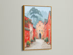 Village Street art with a gold frame. The gold frame enhances the vintage charm of this red and peach artwork. Add a touch of elegance to your entryway with this framed travel art. This artwork creates a unique ambiance.