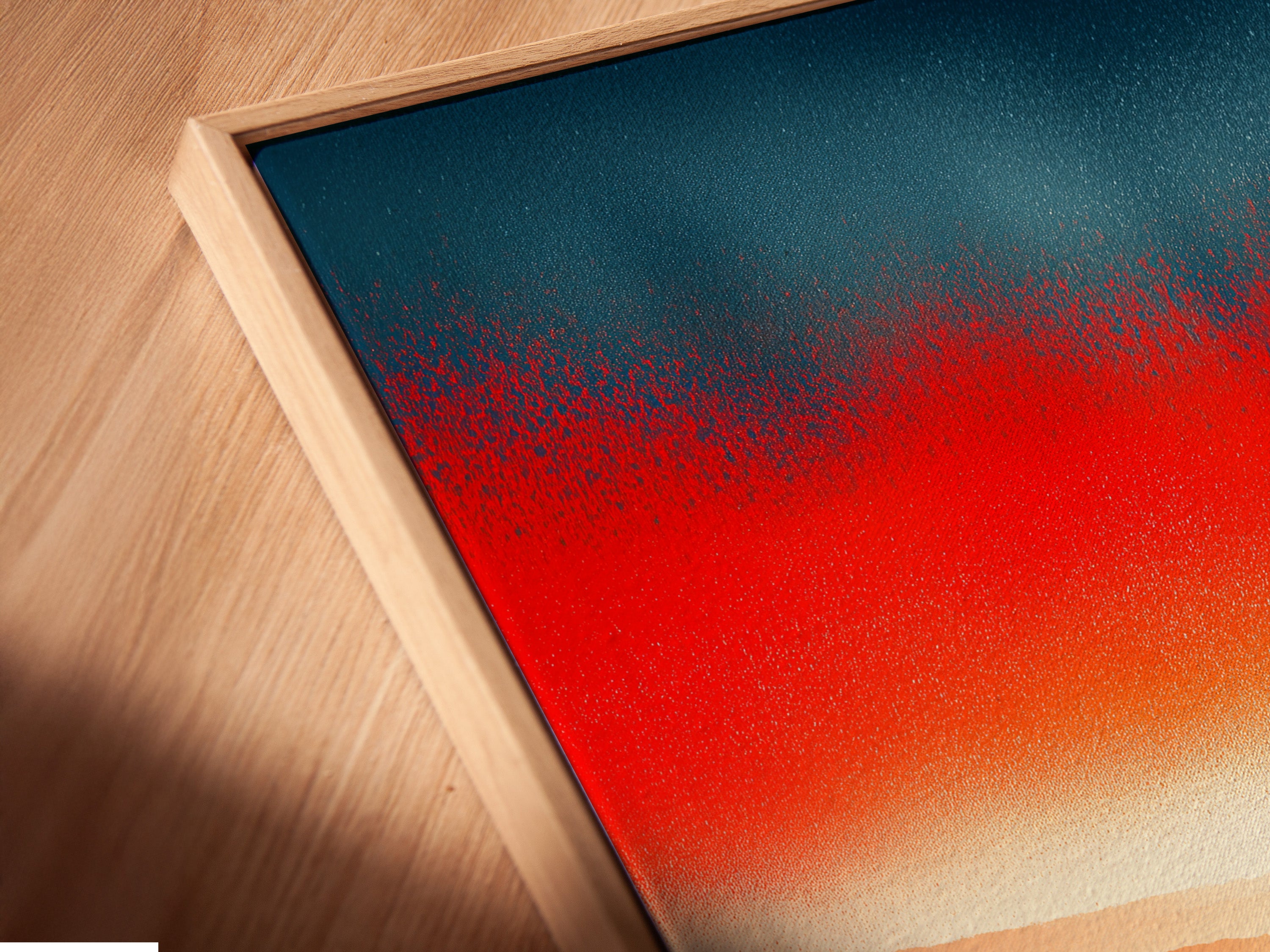 A close-up angled view of a canvas print in a floating frame. The abstract sunset artwork features a red orange mountain landscape. This modern art piece is ideal for enhancing your home decor.