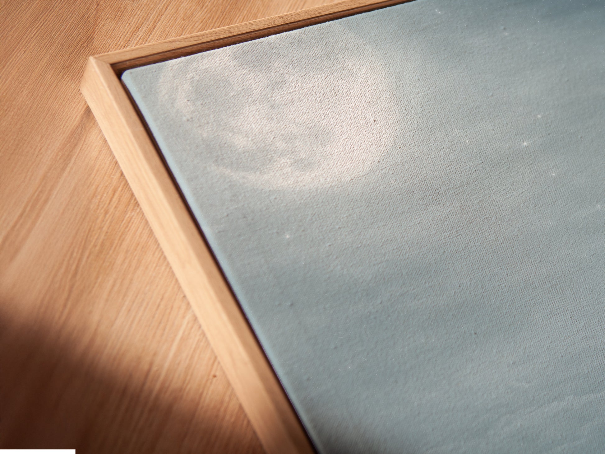 A close-up angled view of the Cat Moon Canvas Print in a floating frame. The floating frame creates a modern gallery look. Enhance your space with this beautiful celestial artwork. Perfect for adding a touch of whimsy to your home decor. This kitten canvas makes a thoughtful gift.