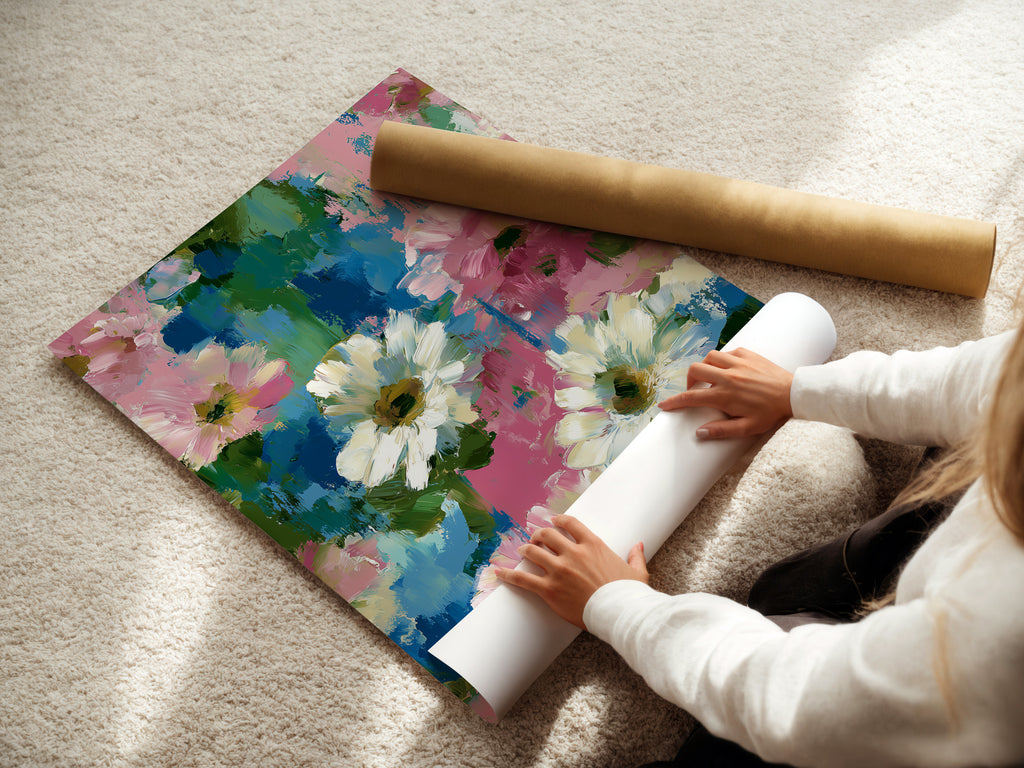 A woman is carefully rolling a fine art poster paper print of floral artwork. The pink and blue flower wall art is being prepared for display. Impressionist botanical artwork perfect for adding a touch of spring. Ideal for homeowners and interior stylists. This daisy art print enhances your home decor. Abstract flowers bring garden charm indoors. Shabby chic art for a refined look.
