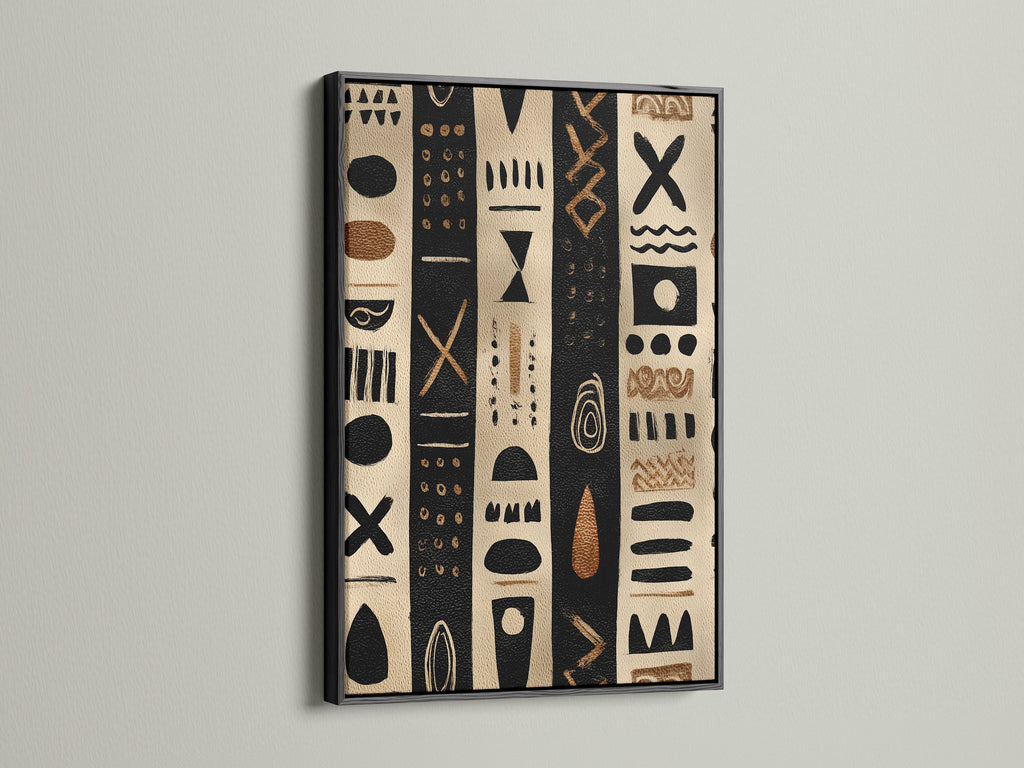 Artwork in a black frame. The artwork has black and tan stripes with tribal inspired shapes. The artwork is hanging on a white wall. The black frame makes the artwork pop. This artwork is perfect for any room in your home.