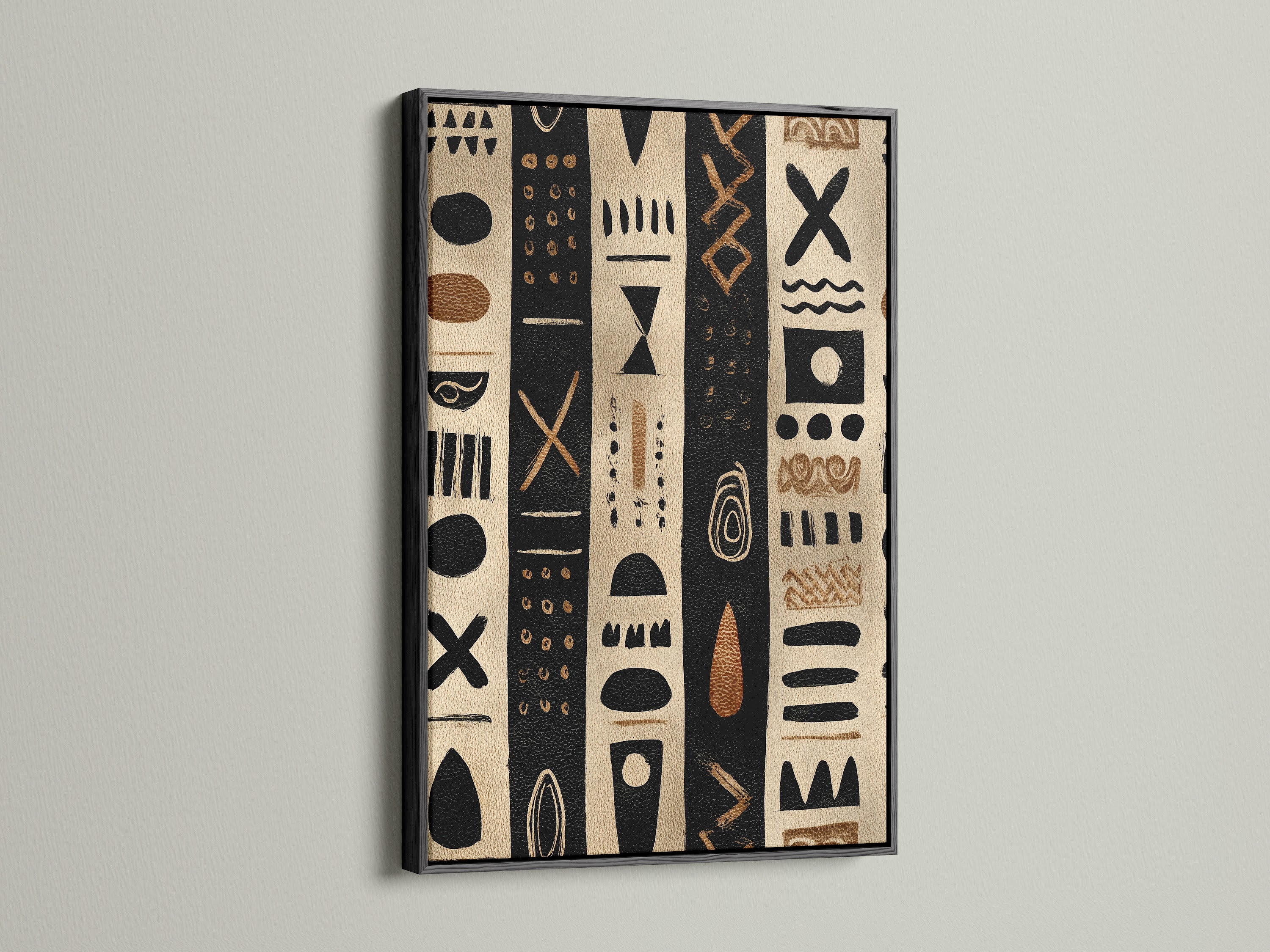 Artwork in a black frame. The artwork has black and tan stripes with tribal inspired shapes. The artwork is hanging on a white wall. The black frame makes the artwork pop. This artwork is perfect for any room in your home.