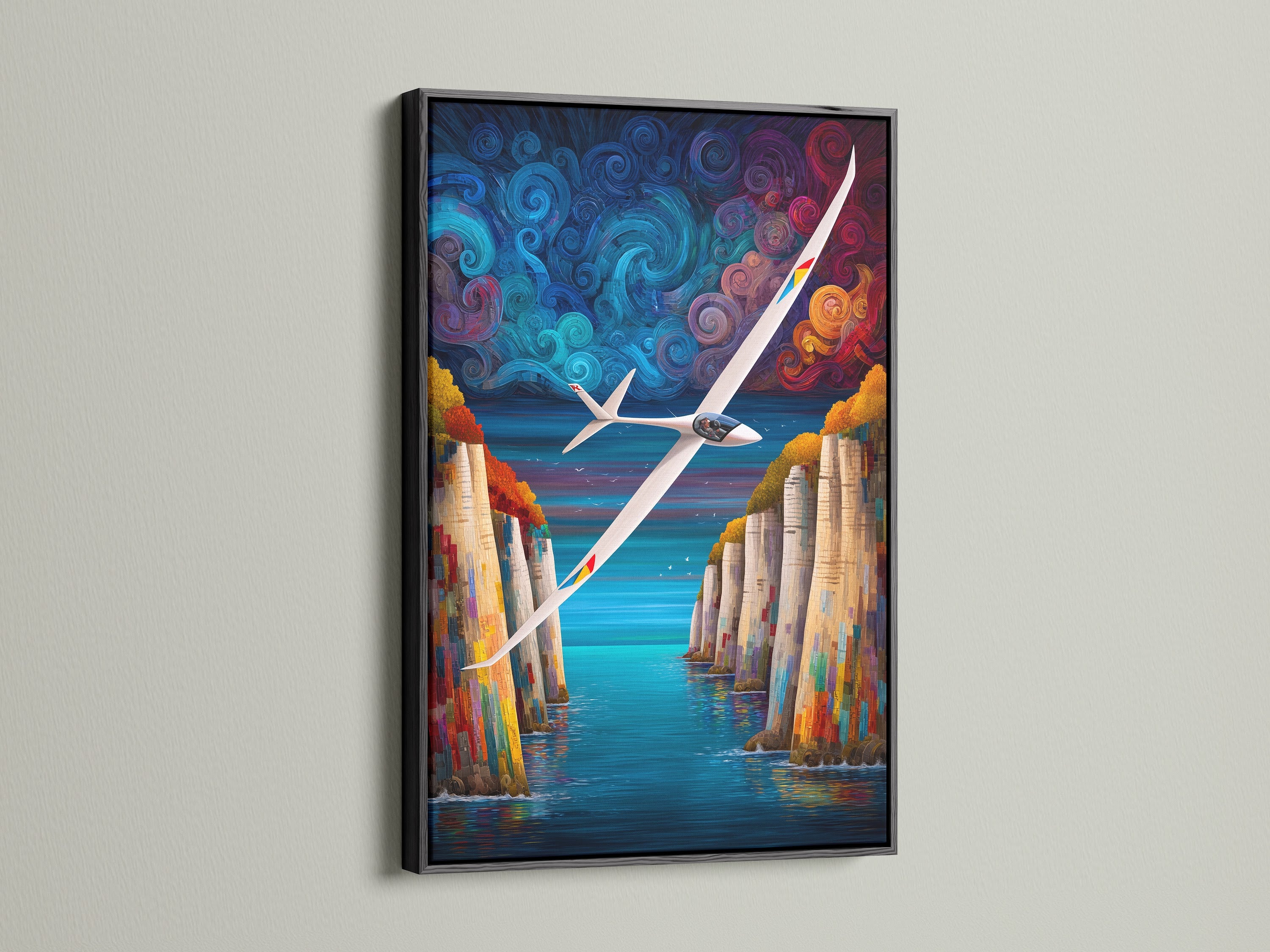 Sailplane artwork with a black frame. This aviation wall print shows a stunning cliff landscape. The colorful art adds a modern touch to any room. It is great for pilots and homeowners alike