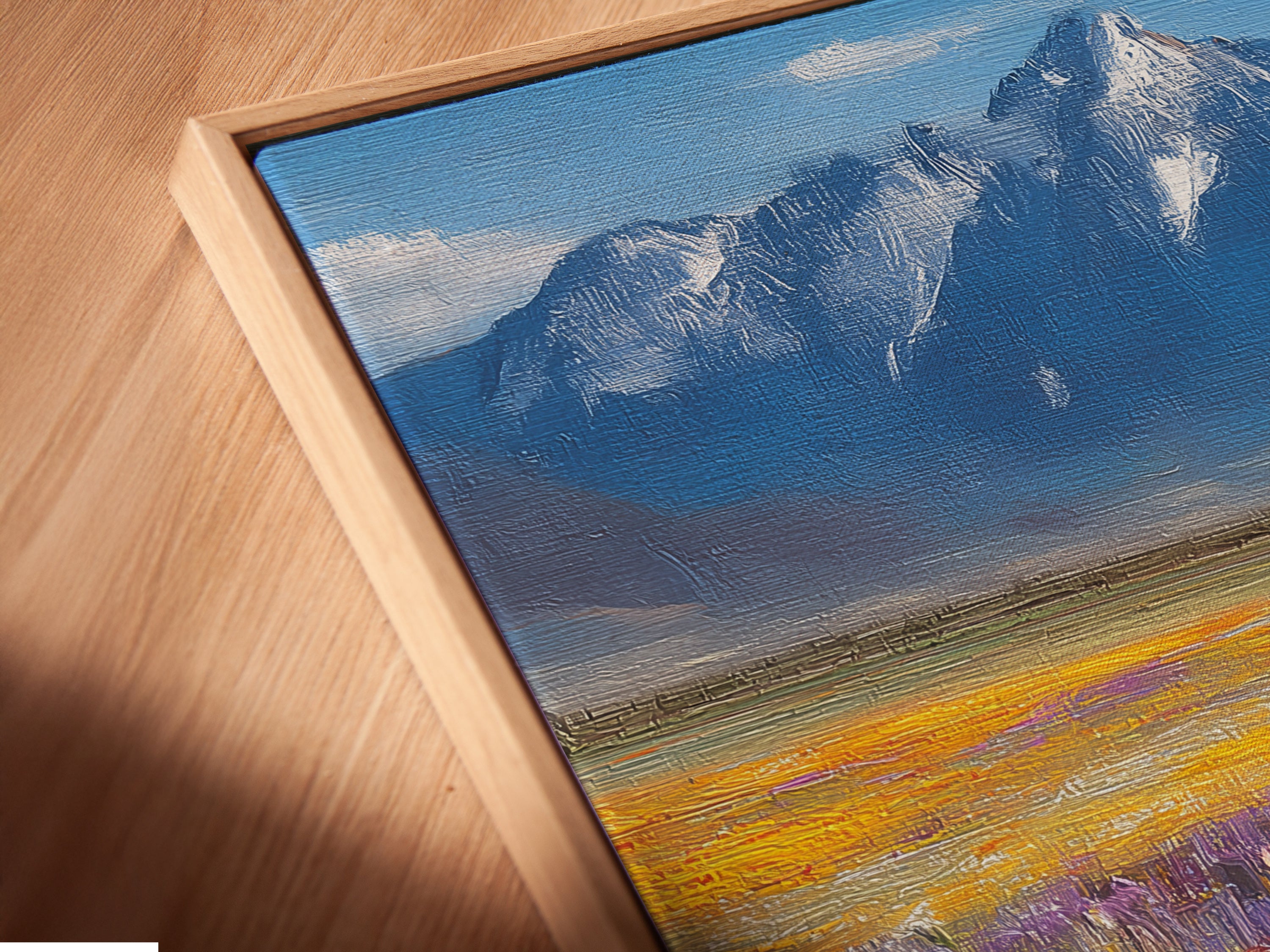 Close-up of a canvas print in a floating frame. The wildflower meadow artwork features a stunning mountain landscape. The floating frame enhances the art's contemporary appeal. This colorful poppy field painting adds depth and dimension. Perfect for modern interiors seeking nature-inspired decor. Explore our framed art options.