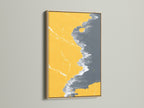 Abstract Coastline Canvas Print in an Oak Frame. The modern artwork combines mustard yellow and gray tones. It creates a stylish seascape art piece for any room. Enhance your space with this unique coastal artwork.