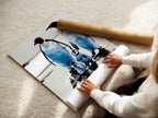A woman rolls a fine art poster paper featuring a penguin family. Ideal for homeowners renters and parents seeking serene nursery decor or distinctive wall art. Perfect for living rooms bedrooms nurseries and children's rooms.