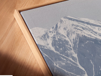 A close-up angled view reveals a canvas print in a floating frame. The mountain flower artwork features a snowy peak landscape. It is a modern decor piece for any room. The lilac flowers add a touch of wilderness art to your walls.