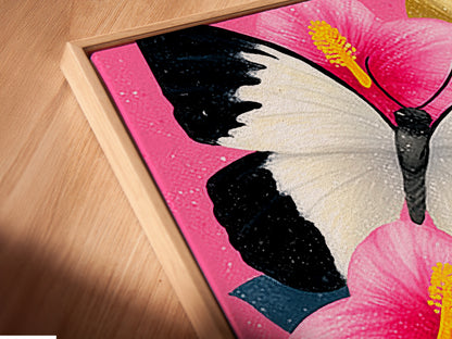 Angled close up of the Butterfly Canvas Artwork in a floating frame. This artwork features a pink hibiscus wall art with white butterflies. The floating frame adds a modern touch to the piece making it perfect for any room.