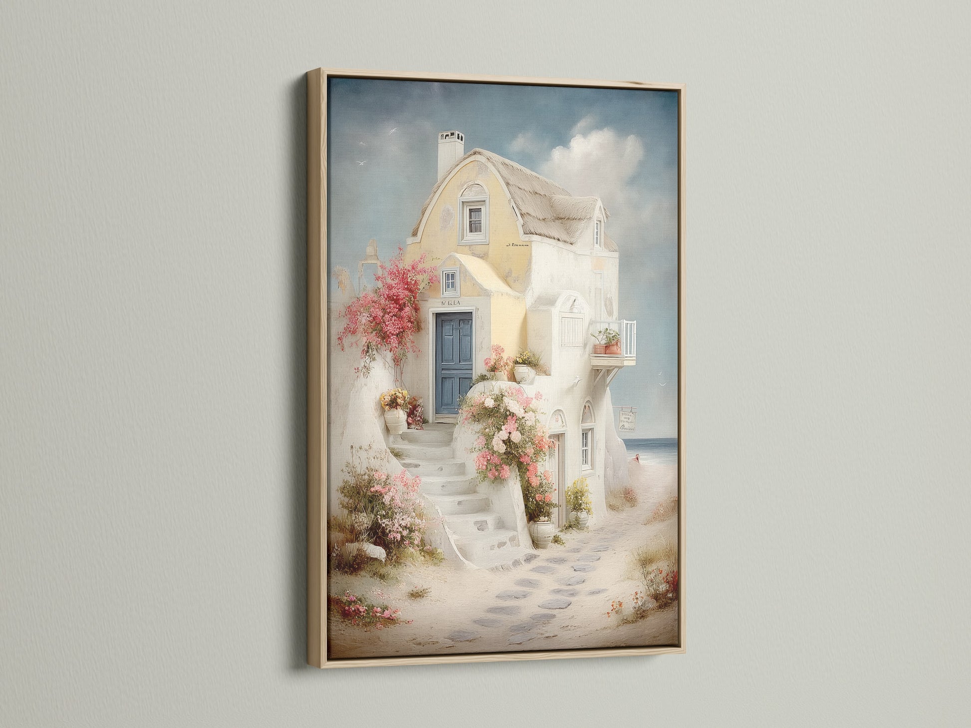Framed coastal artwork in an oak frame. The artwork features a Santorini-style house canvas with a blue door and floral stairway. This sea view print brings Greek island art to your vacation home decor. Elevate your bedroom wall art with this piece.