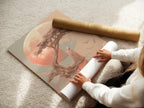 A woman is carefully rolling a fine art poster paper print. The Zen Tree art is perfect for peaceful wall art. This coral pink print is ideal for meditation decor. Enhance your space with serene artwork.