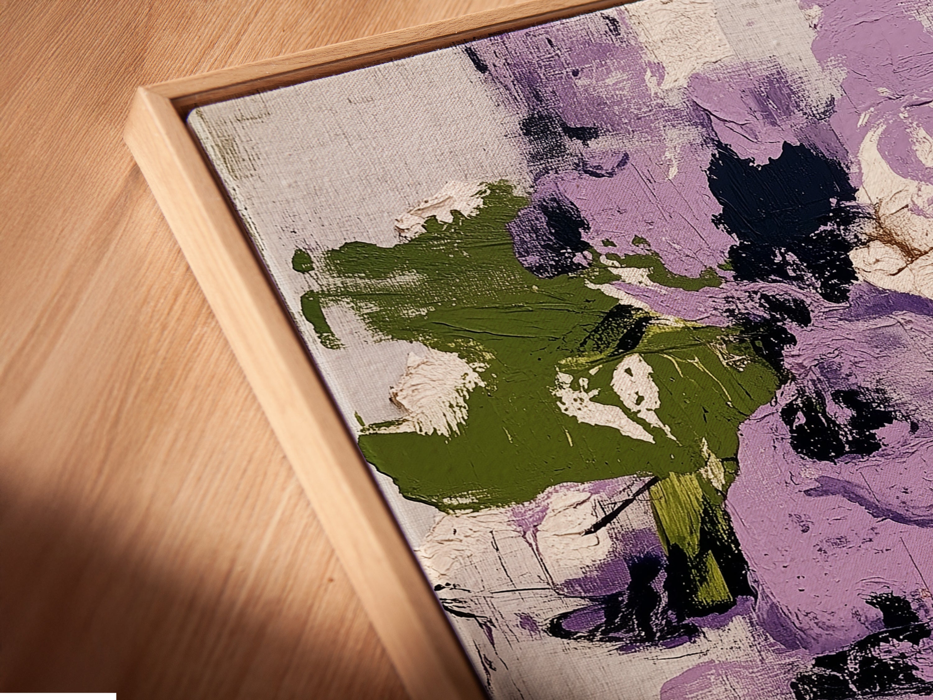 A close-up angled view of a canvas print in a floating frame. The artwork showcases abstract floral patterns with purple and green hues. This contemporary botanical print adds a modern touch to any space. The floating frame enhances the artwork's visual appeal and style.