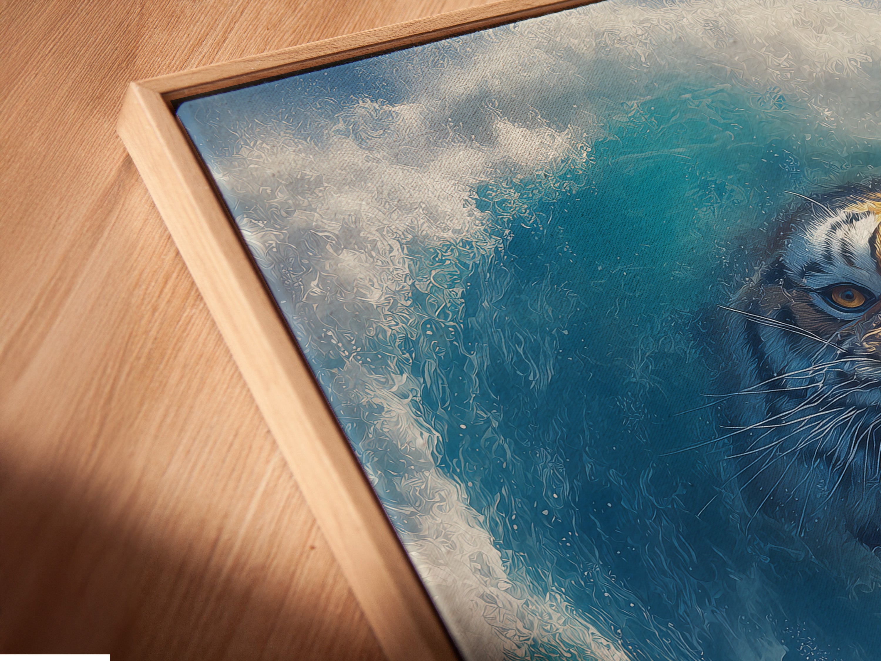 Angled close up of the surreal tiger wave art. The artwork is a canvas print in a floating frame. The surfer rides a blue ocean wave. The tiger is a fantasy animal. A great piece for office decor.