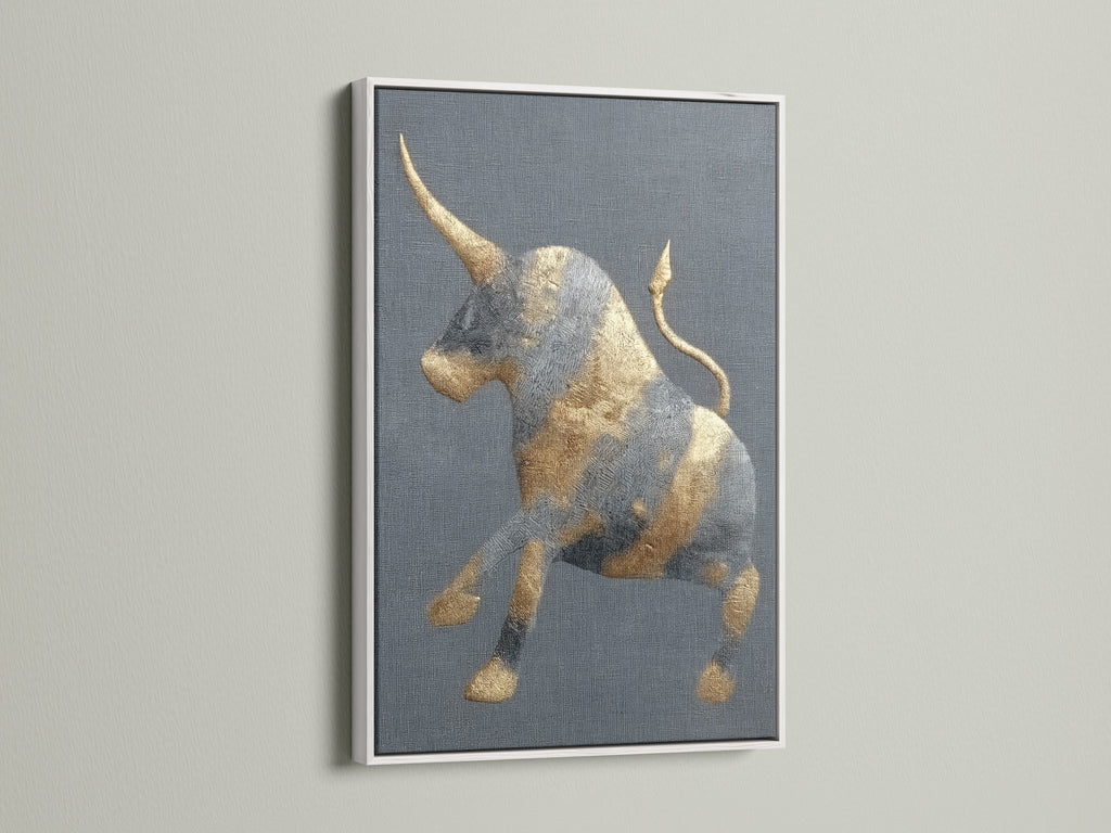 This is a golden bull artwork with a white frame. The frame offers a clean modern look. The abstract print is perfect for a study room. It will also look great in an office. This animal canvas fits minimalist eclectic or industrial styles. It's perfect for homeowners and renters.