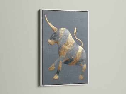 This is a golden bull artwork with a white frame. The frame offers a clean modern look. The abstract print is perfect for a study room. It will also look great in an office. This animal canvas fits minimalist eclectic or industrial styles. It's perfect for homeowners and renters.