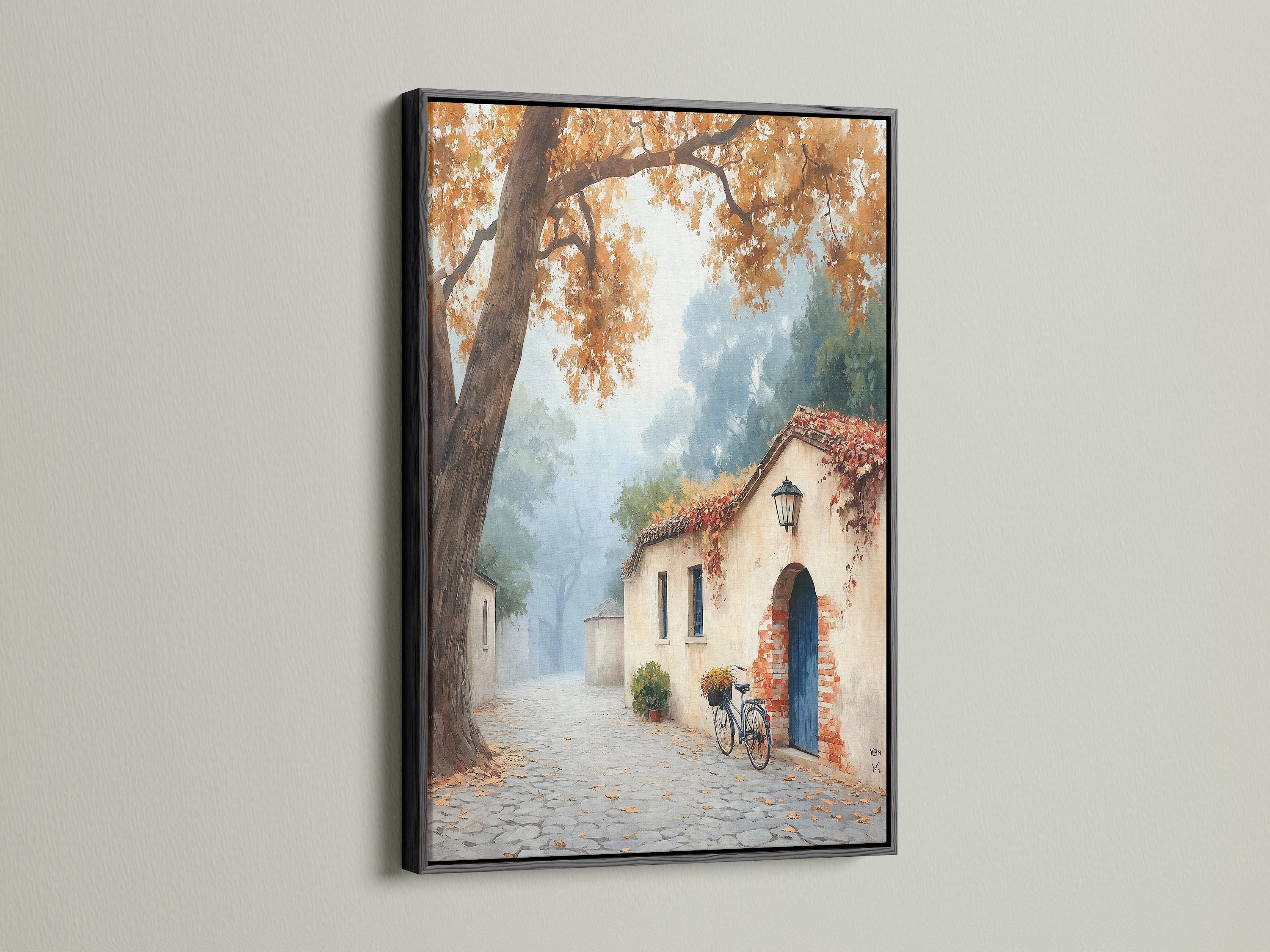 Italian Village artwork with a black frame. The black frame makes the autumn landscape stand out. This European architecture artwork is perfect for a modern touch. Notice the cobblestone street and fall colors. It's great for rustic home decor.