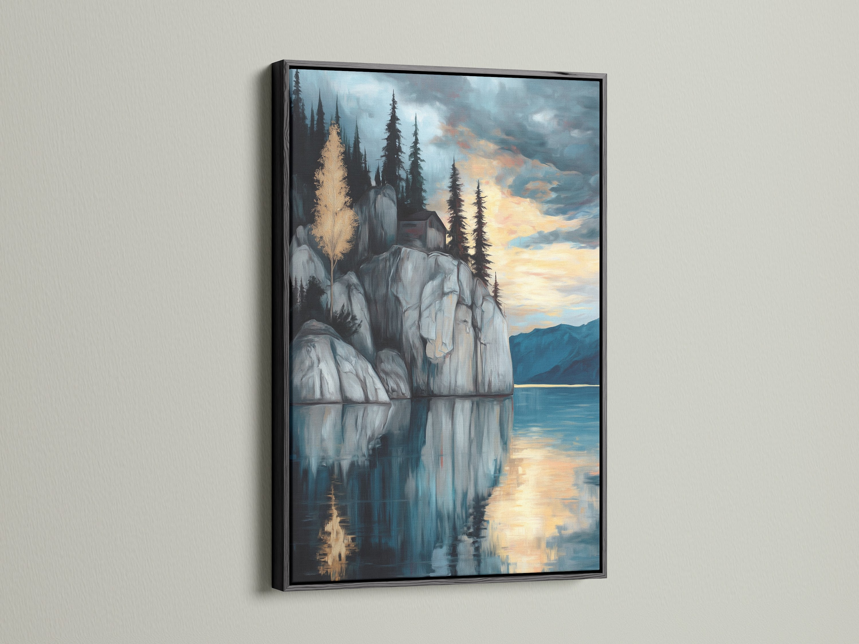 Lakeside Cliff canvas print with a black frame. Ideal serene mountain wall art for a modern study room. This moody landscape artwork presents a tranquil scene. Blue and gray hues enhance the reflective art. The mountain painting and water reflection make this a scenic art print.