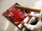 A woman is carefully rolling a fine art poster paper. The paper features an abstract red artwork. This ensures the textured impasto wall art remains pristine. Perfect for those who appreciate contemporary palette knife painting. Ideal for homeowners and creative professionals seeking modern art.