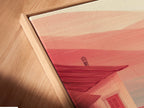 A close up angled view displays a canvas print in a floating frame. The coastal house artwork features a red boat. The minimalist seascape is perfect for adding a serene touch. Ideal for living room wall art and beach house decor. Elevate your space with this elegant and calming artwork. Discover nautical wall art.