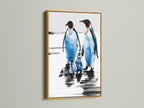 Penguin art print with a gold frame. The arctic canvas creates a coastal atmosphere. It is a perfect piece of animal artwork for blue and white themed rooms. This winter wall art makes a charming animal lover gift.