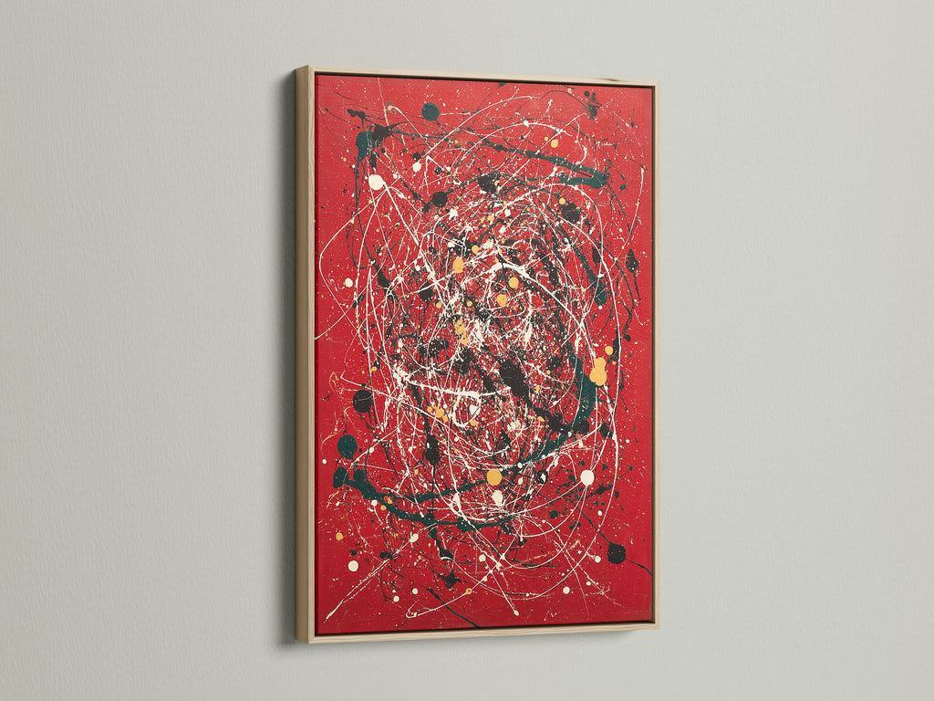A striking red canvas print featuring abstract wall art. The artwork is beautifully framed in oak. This modern piece uses splatter art and paint drips for a contemporary look. Ideal for adding a bold statement to any room. Perfect for those seeking modern home art.