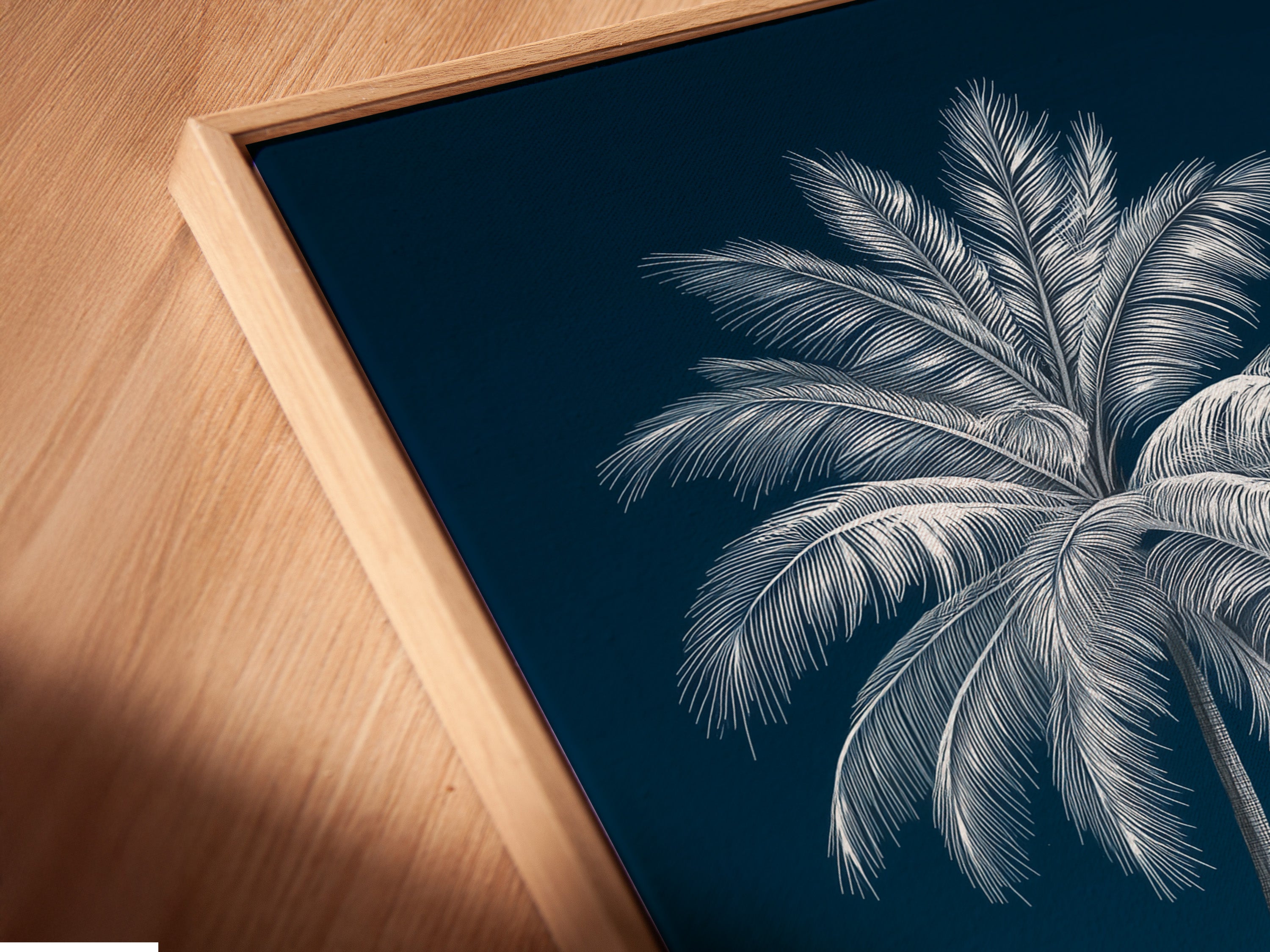 Angled close-up of a canvas print in a floating frame. Navy blue beach canvas print adds depth to any room. Coastal wall decor for a modern and stylish home.