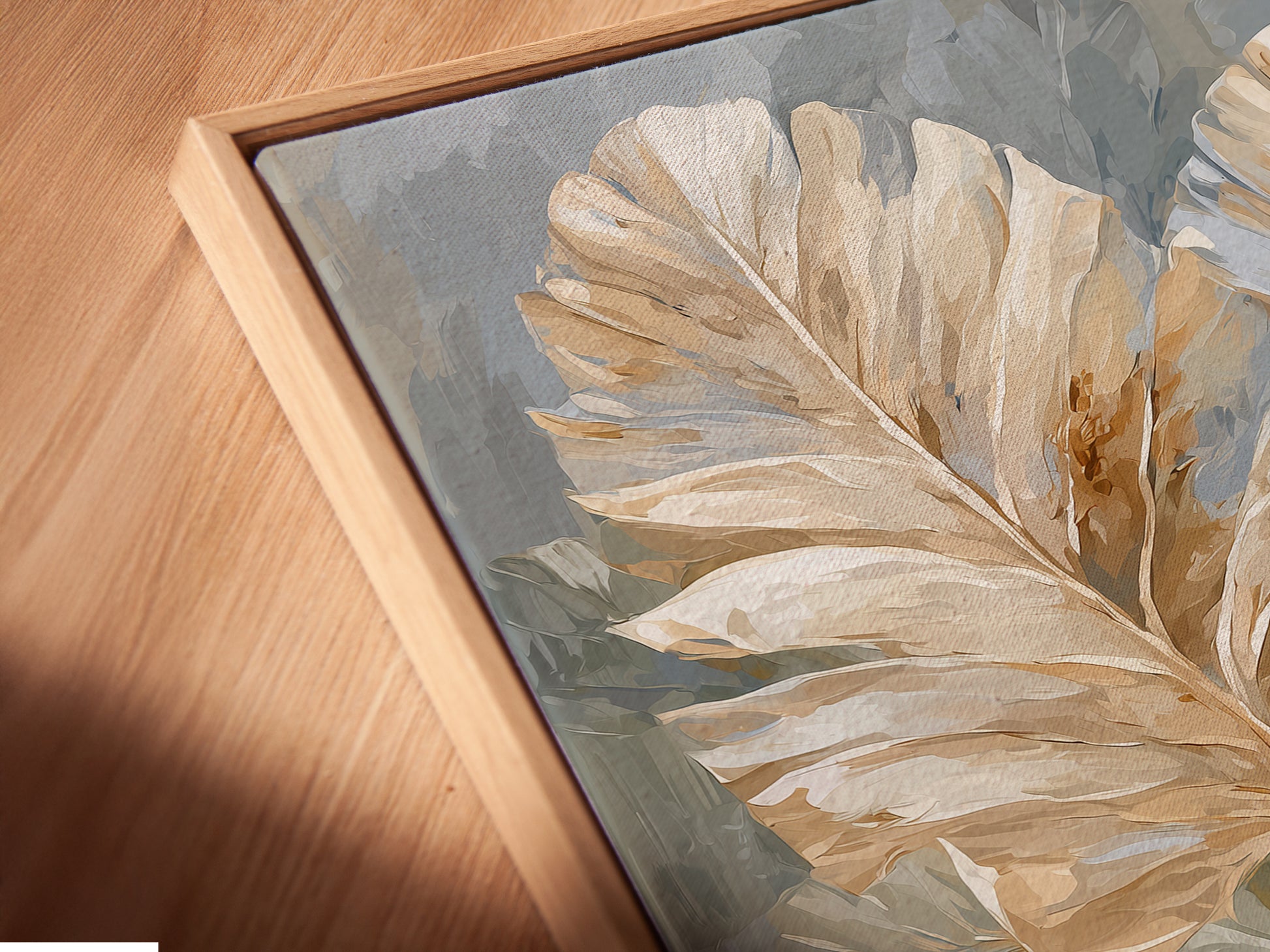 A close-up angled view of a beige and blue neutral floral canvas print in a floating frame. The artwork is a soft floral print. It would look great in minimalist Scandinavian or contemporary spaces. This art is perfect for a bedroom.