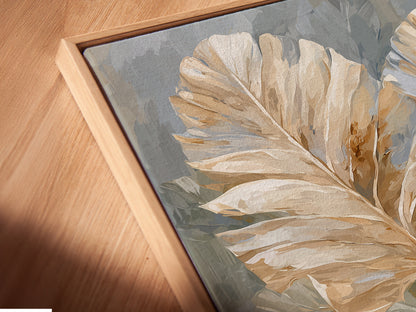 A close-up angled view of a beige and blue neutral floral canvas print in a floating frame. The artwork is a soft floral print. It would look great in minimalist Scandinavian or contemporary spaces. This art is perfect for a bedroom.